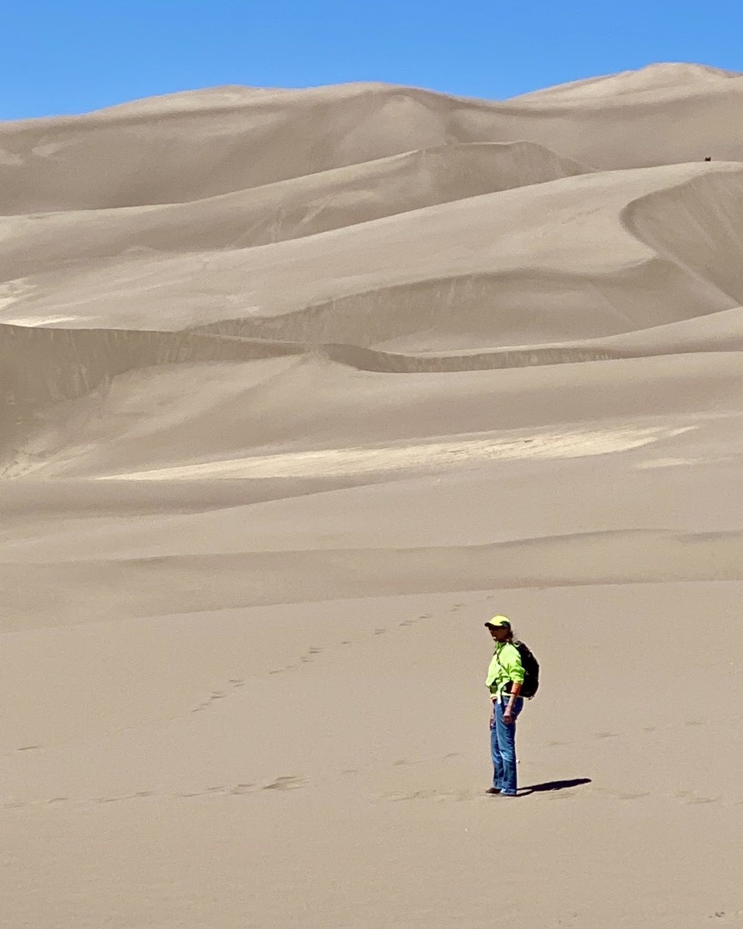 Cindy Orcutt preparing to climb the dunes at Sand Dune National Park in southern Colorado. Hiking there is fairly strenuous due to steep pitches and soft sand. Each step forward is accompanied with a half step sliding backward. #greatsanddunesnatuonalpark #orcuttphotography.com #hikingthedunes #revelvantookusthere