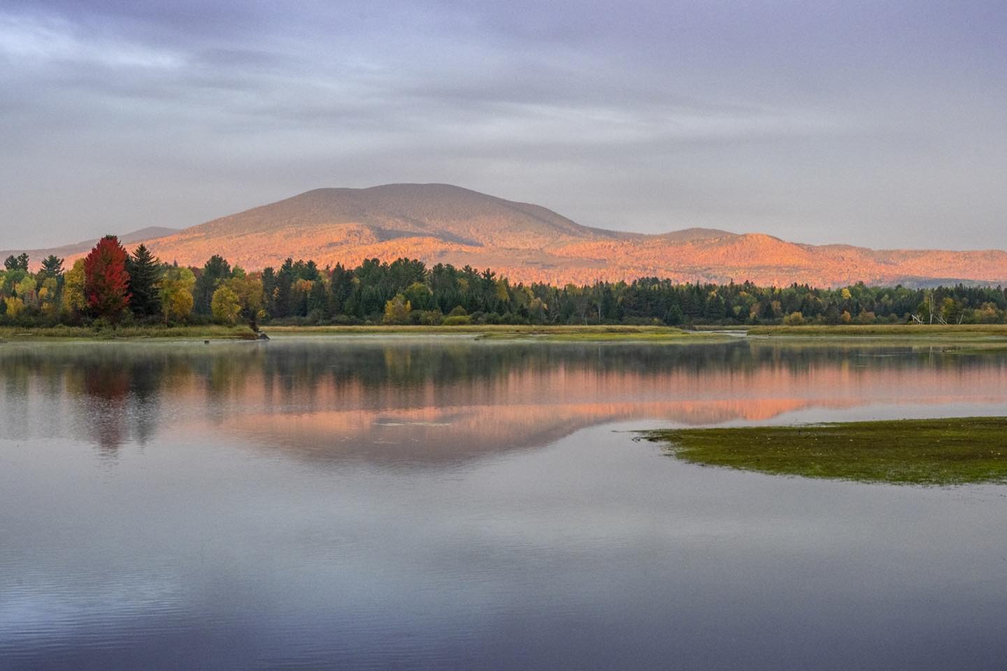 Early morning mountain light illuminates East Kennebago Mountain, photographed from the Flagstaff Lake Causeway in Stratton, Maine. Cindy Orcutt recorded the fleeting moment just before the narrow gap in the low clouds closed. #eastkennebagomountain #strattonmaine #flagstafflake #orcuttphotography.com #fallphotographyinmaine