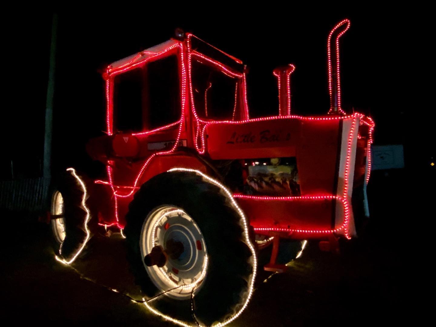 Massey Ferguson tractor outlined with Christmas Lights in New Paris, OH at Today’s Harvest Farm Stand, our berth for the night as we drive west. Photo by Cindy Orcutt. #masseyfurgeson #newparisohio #orcuttphotography #ohioruralphotography
