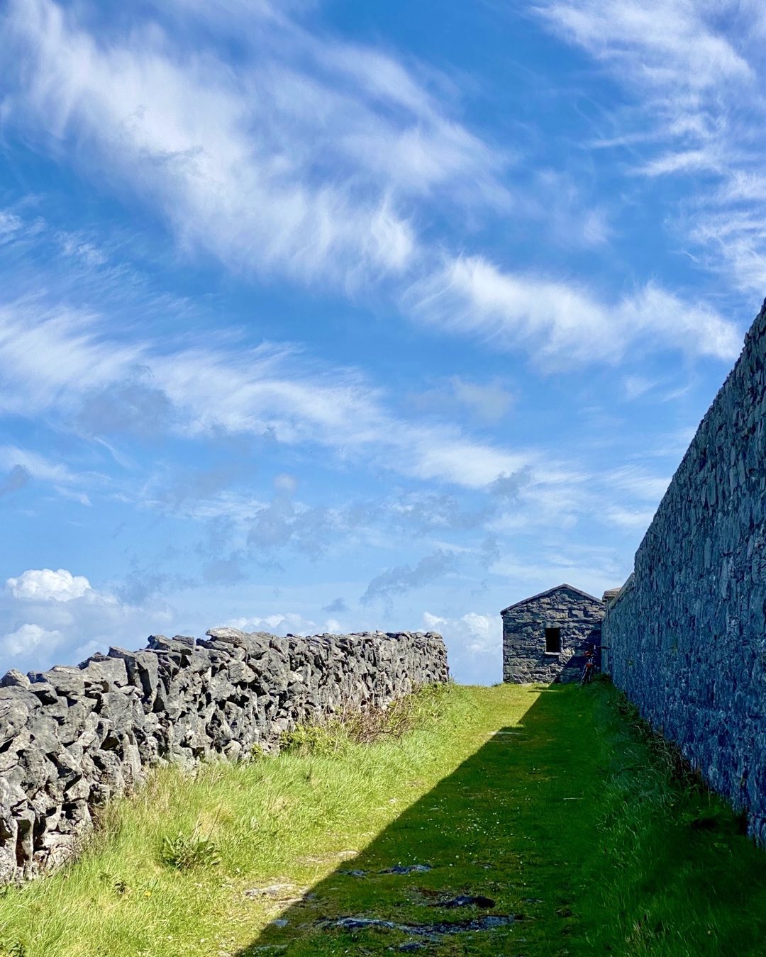 Stone walls and buildings on the bright green landscape are everywhere in Western Ireland. This strong composition by Cindy Orcutt clearly expresses these iconic elements on Inis Mor in the Aran Islands. #ireland #inismoraranislands #westernireland #stonewalls #orcuttphotography