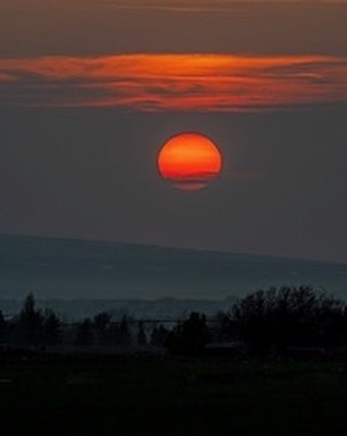 The atmosphere here in Teton Valley has been hazy the past few days with smoke from the extensive forest fires in western Canada. Sunsets are marked by the red ball sun disappearing behind low cloud cover near the horizon. #tetonvalleyidaho #driggsidaho #bestofthegemstate #idahosunsets #orcuttphotography.com