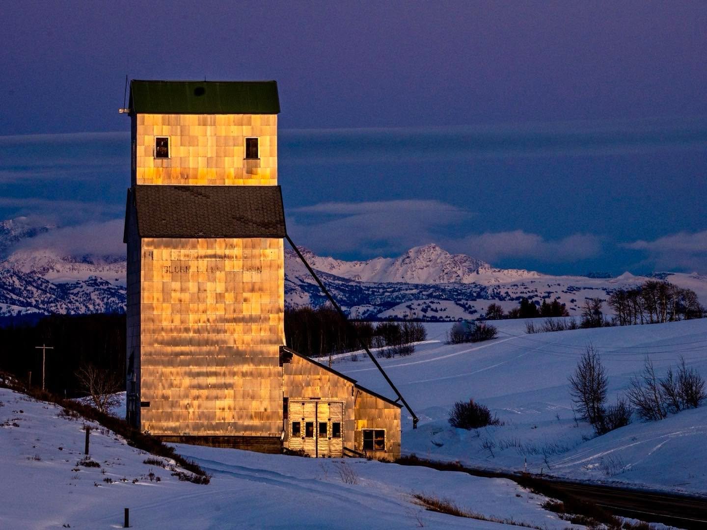This antique Pillsbury grain elevator is located about half-way between Tetonia and Ashton in eastern Idaho. The exterior siding is low cost galvanized corrugated panels, but in the low evening light, the siding takes on the colors of the setting sun, creating this beautiful lantern on the open landscape!